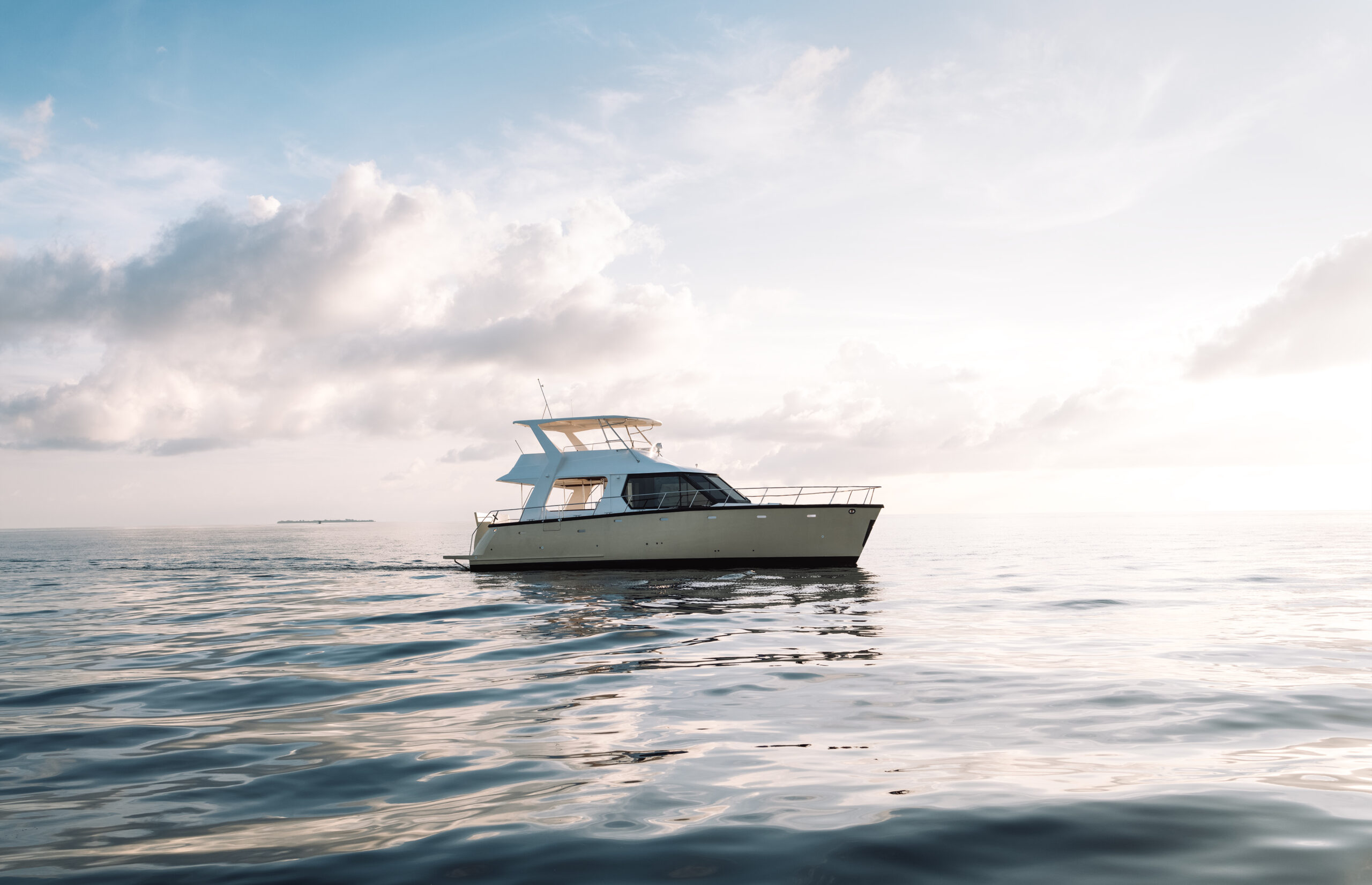 A modern luxury yacht on the high seas. A white boat in the calm clear water of the ocean. Seascape with a ship. Blue sky and fluffy clouds on the horizon. Liveaboard. Rest, relaxation and vacation